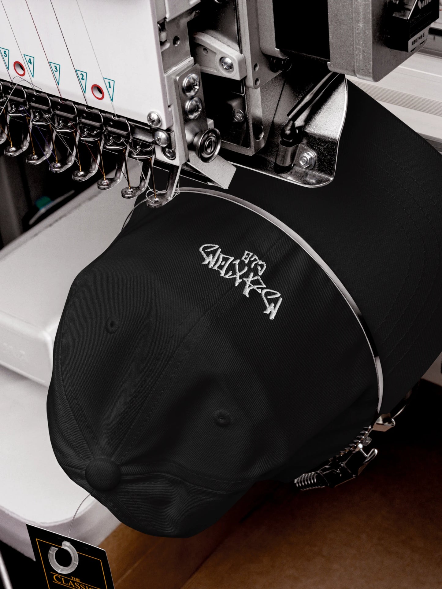 Embroidery process of the ECHO Black Streetwear Baseball Cap featuring MAXOMclo graffiti logo craftsmanship.