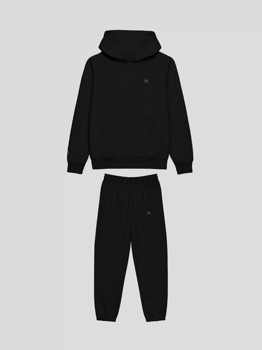 Front view of REMNANT. NOIR THEORY.01 black oversized hoodie and sweatpants set – clean minimalist streetwear design with embroidered logo