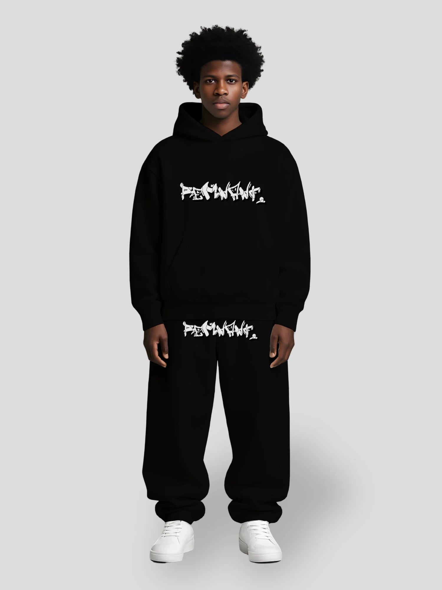 Dark-skinned male model wearing all-black oversized hoodie and sweatpants with graffiti logo — REMNANT. DROP.ØNE Collection bundle outfit
