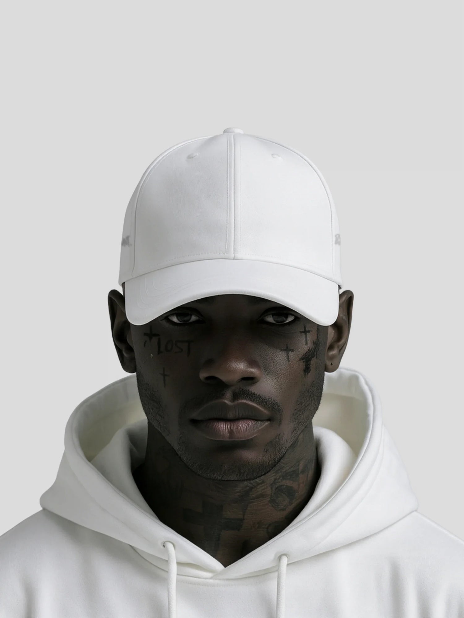 Dark-skinned male model wearing a minimalist white streetwear cap and hoodie — REMNANT. Accessories Collection product image for fashion-driven young adults