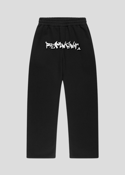 Black oversized streetwear sweatpants with graffiti print on front waistband – urban unisex design, part of Drop One set.