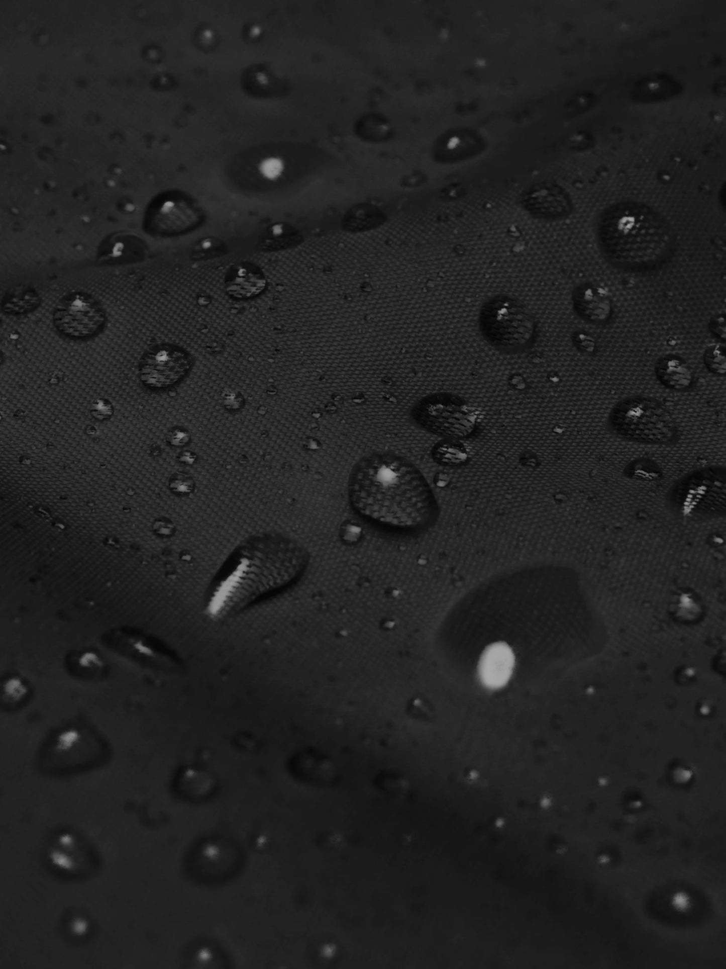 Close-up of waterproof texture on the black street style windbreaker jacket – lightweight, durable, and moisture-resistant.