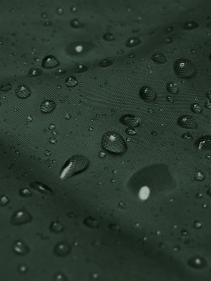 Waterproof fabric close-up showing droplets on the forest green minimalist windbreaker jacket – PETA-approved vegan outerwear.