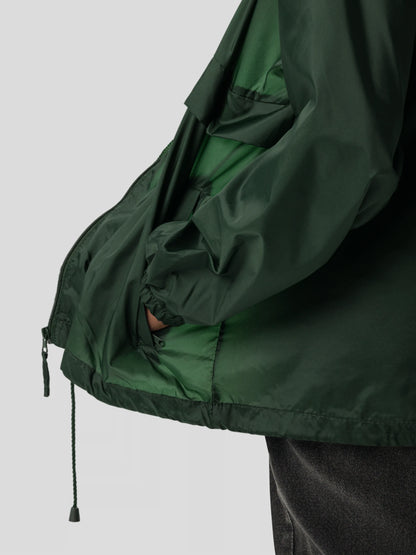 Pocket and fit detail of the forest green unisex windbreaker jacket, crafted for urban and outdoor functionality.