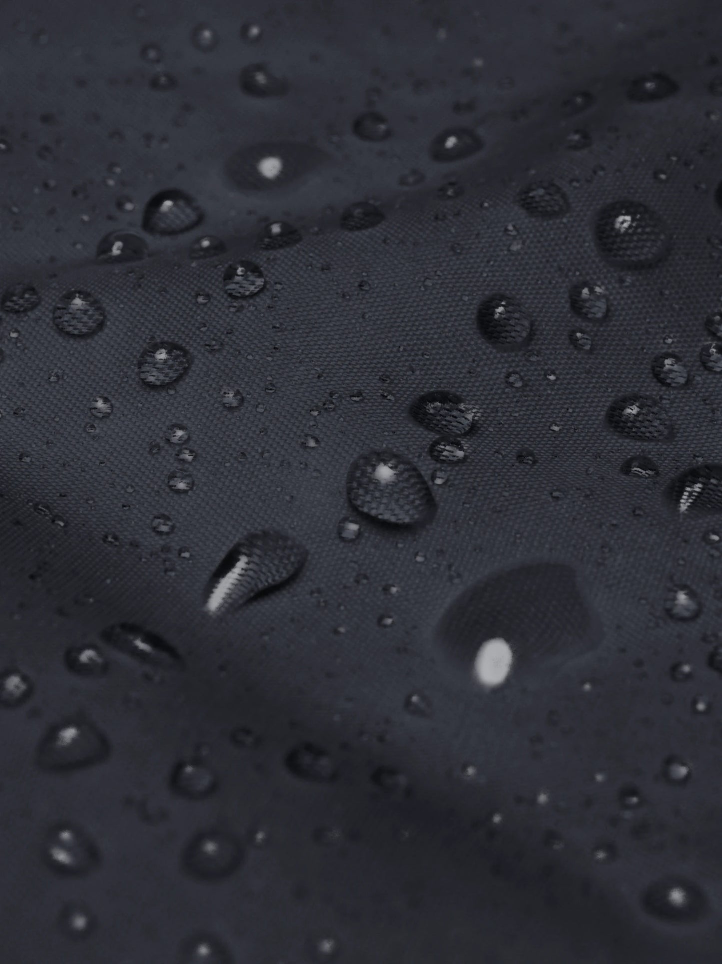 Close-up of water droplets on the navy blue streetwear windbreaker jacket – showing durable, windproof nylon streetwear texture.