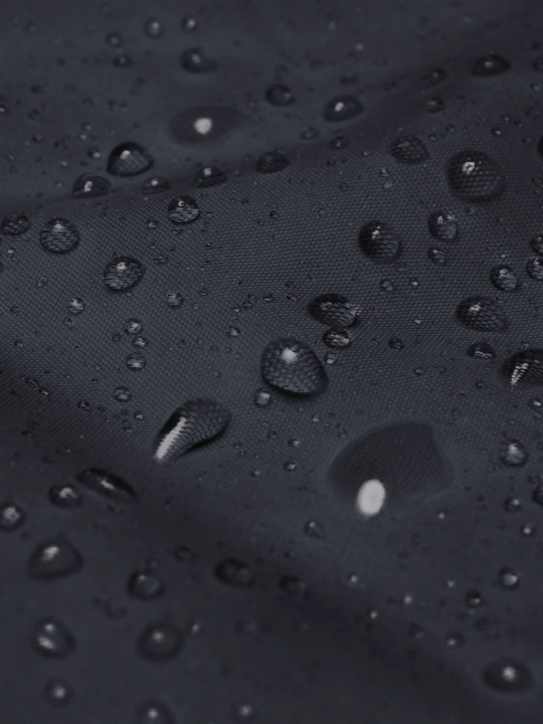 Close-up of water droplets on the navy blue streetwear windbreaker jacket – showing durable, windproof nylon streetwear texture.