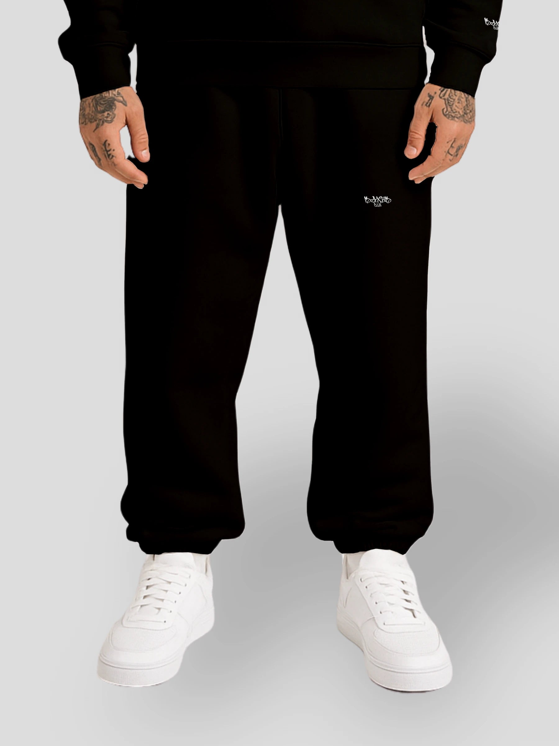 Model wearing heavyweight cotton baggy joggers in black — comfortable oversized sweatpants with a small logo, crafted for high-end streetwear appeal. These gender-neutral relaxed fit sweatpants combine Y2K streetwear aesthetics with premium fleece fabric for ultimate comfort.
