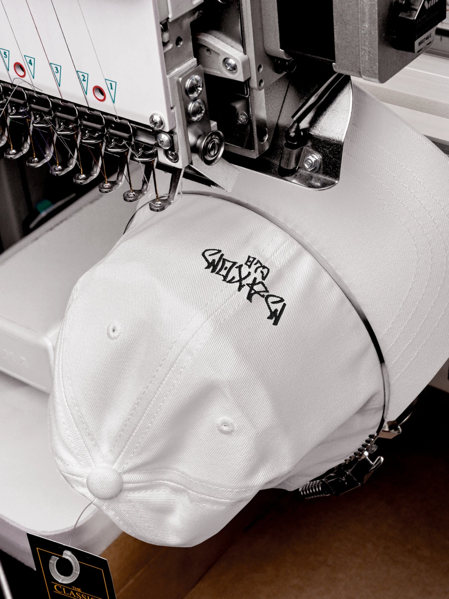 Embroidery detail of the ECHO White Streetwear Baseball Cap during production process.
