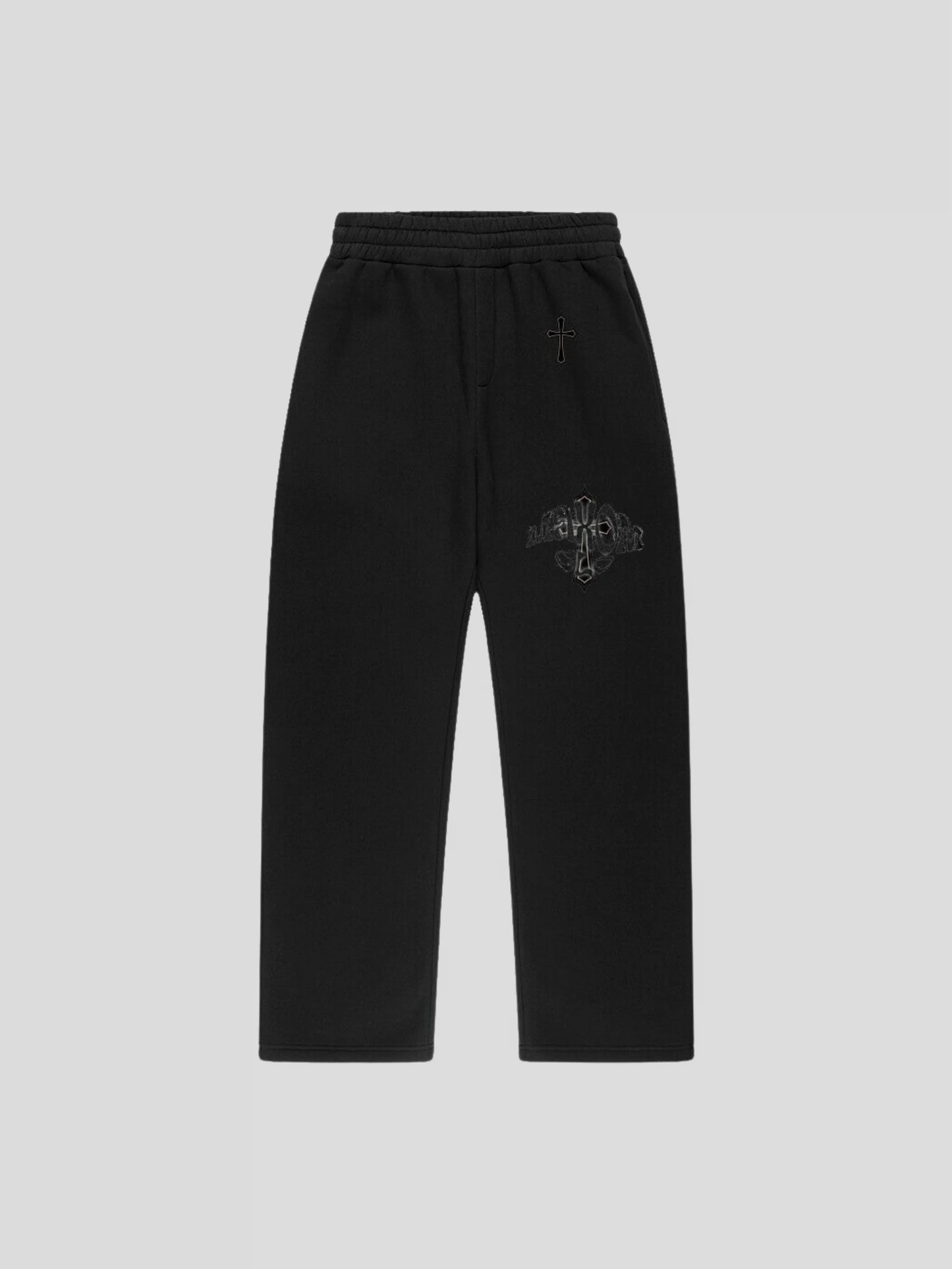 Front of the black oversized baggy sweatpants – luxury unisex streetwear pants with minimalist embroidered cross detail.
