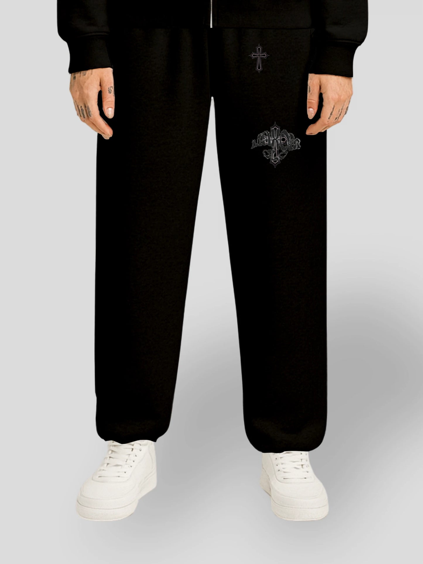 Model wearing the ELYSIUM Oversized Baggy Sweatpants in Black by MAXOMclo – heavyweight 380 GSM cotton streetwear joggers with subtle tonal cross embroidery.