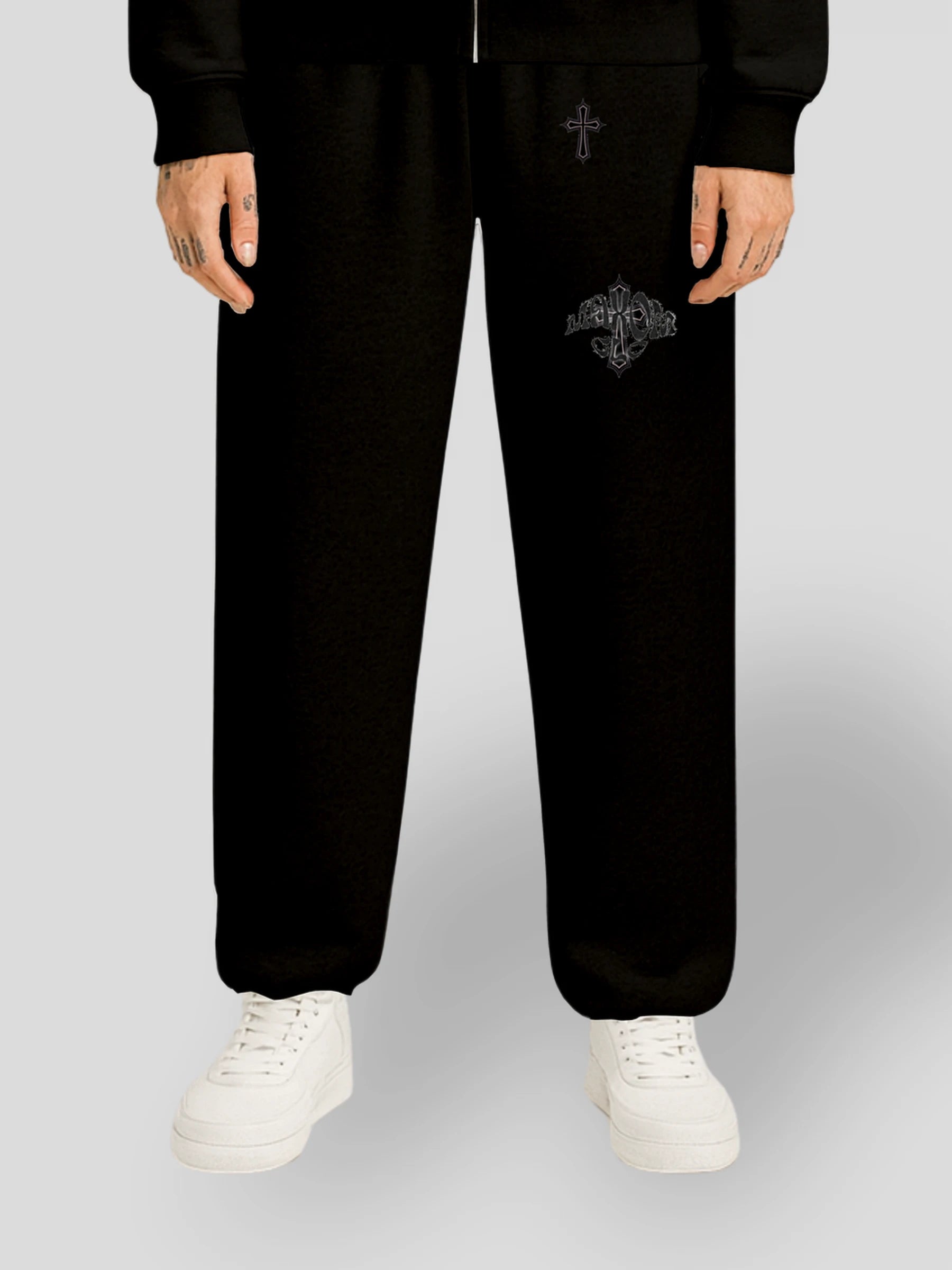 Model wearing the ELYSIUM Oversized Baggy Sweatpants in Black by MAXOMclo – heavyweight 380 GSM cotton streetwear joggers with subtle tonal cross embroidery.