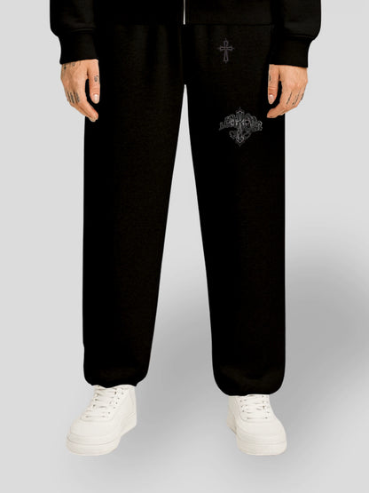 Model wearing the ELYSIUM Oversized Baggy Sweatpants in Black by MAXOMclo – heavyweight 380 GSM cotton streetwear joggers with subtle tonal cross embroidery.