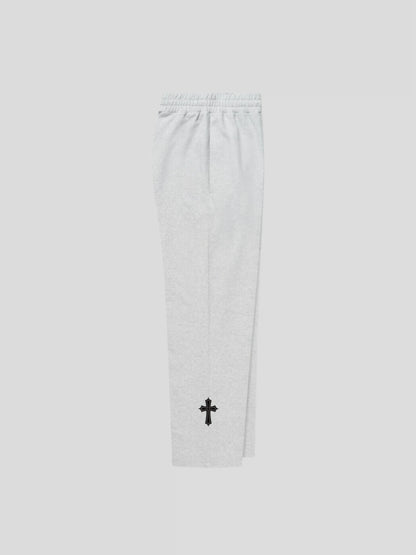 Right side view of the grey unisex baggy streetwear sweatpants by MAXOMclo – luxury oversized joggers with gothic cross embroidery.