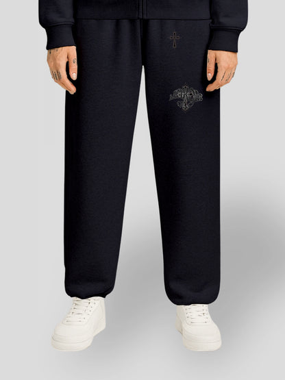 Model wearing the ELYSIUM Oversized Baggy Sweatpants in Navy Blue by MAXOMclo – luxury 380 GSM heavyweight unisex joggers with embroidered gothic cross detail.