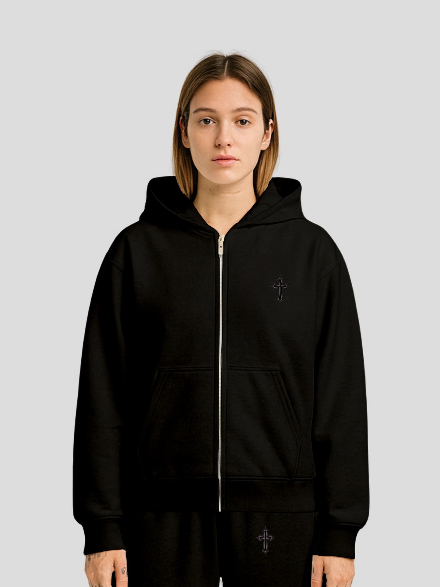 Model wearing the ELYSIUM Oversized Zipper Hoodie in Black by MAXOMclo – high-GSM luxury streetwear hoodie with embroidered black cross detail.