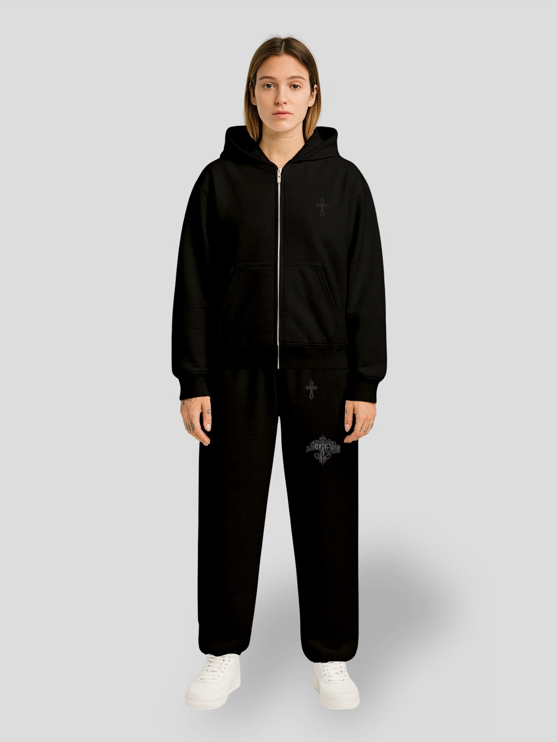 Model wearing the Elysium Set BLACK by MAXOMclo – oversized hoodie and baggy sweatpants set in all-black cotton with minimalist cross embroidery, premium urban streetwear look.