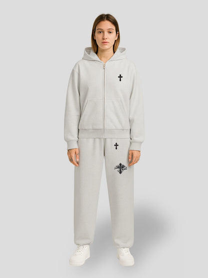 Model wearing the Elysium Oversized Grey Sweatsuit by MAXOMclo – premium heavyweight streetwear hoodie and sweatpants set with minimalist black cross embroidery.