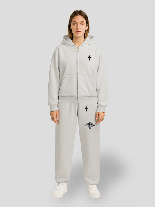 Model wearing the Elysium Oversized Grey Sweatsuit by MAXOMclo – premium heavyweight streetwear hoodie and sweatpants set with minimalist black cross embroidery.