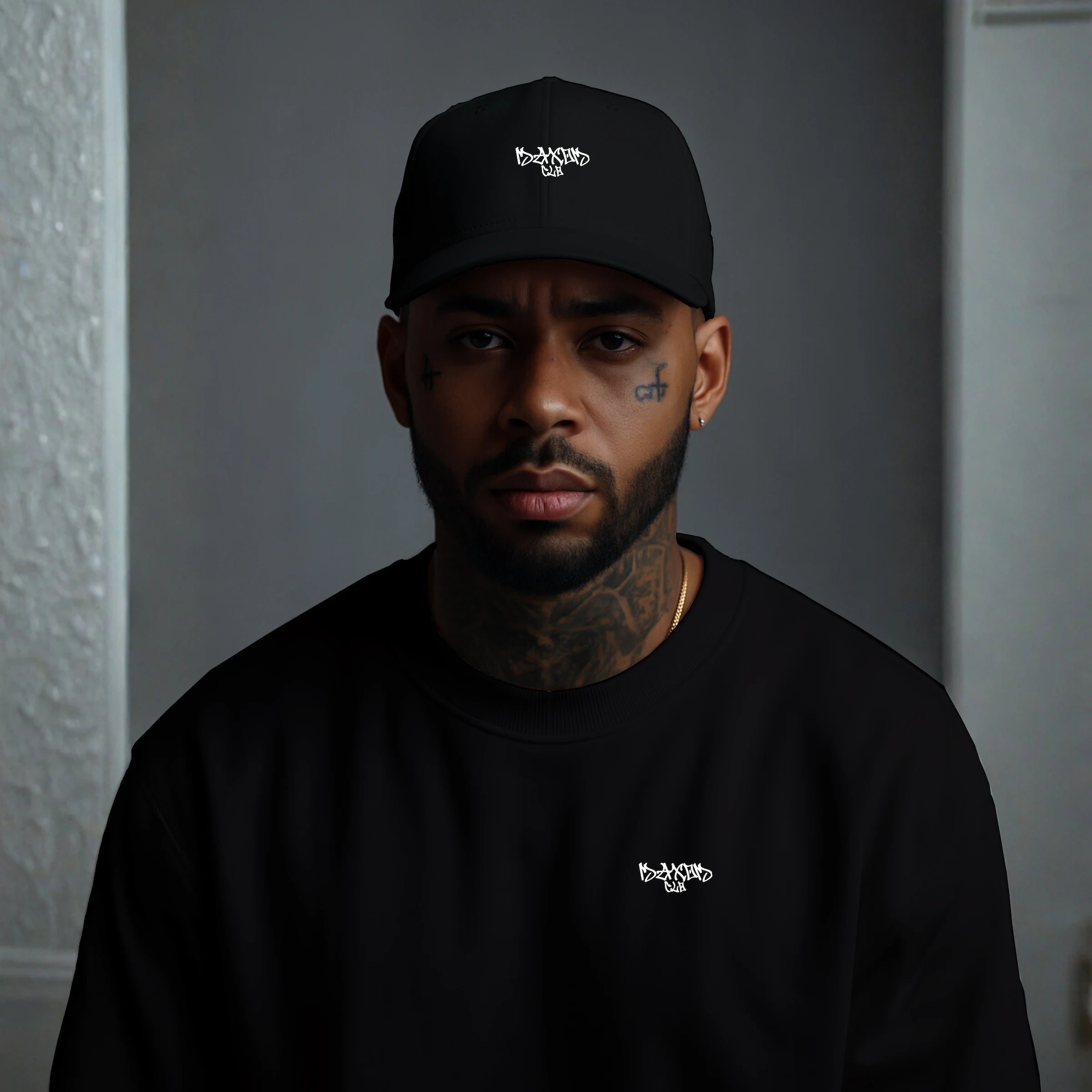 Male model wearing MAXOMclo ECHO black minimalist streetwear cap – low-profile unstructured 6-panel dad hat with embroidered graffiti logo, paired with black oversized crewneck; premium 100% cotton twill urban fashion baseball cap in studio setting.