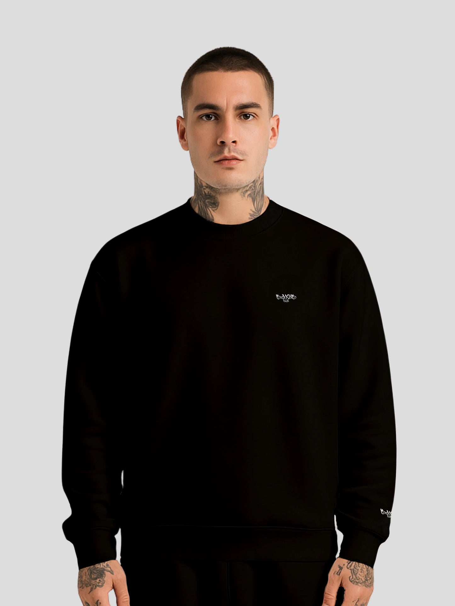 Male model wearing MAXOMclo ECHO BLACK oversized unisex luxury streetwear sweater with minimalist graffiti logo
