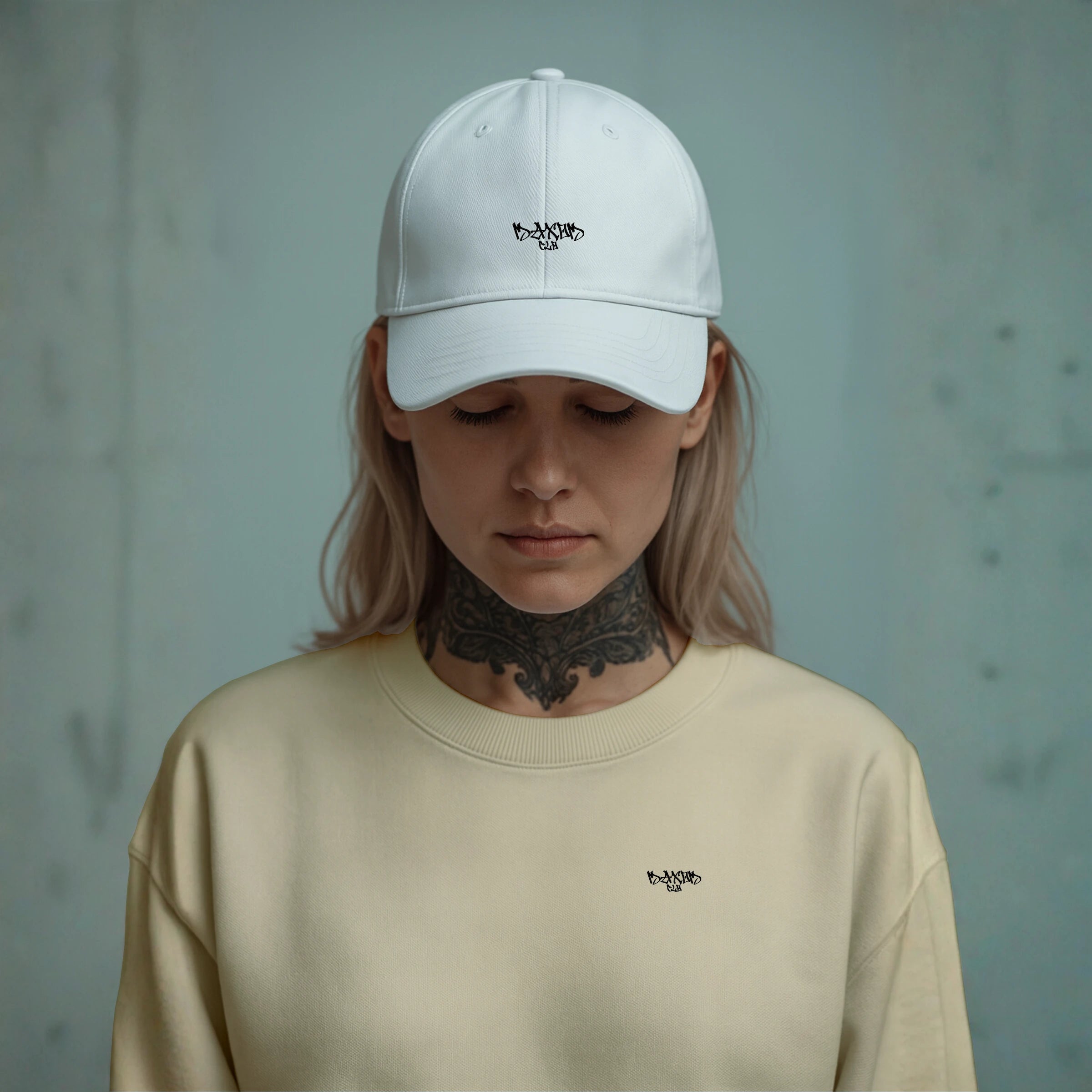 Model wearing MAXOMclo ECHO white minimalist streetwear cap – low-profile unstructured 6-panel dad hat with embroidered logo, paired with neutral crewneck; premium 100% cotton twill baseball cap for urban fashion.