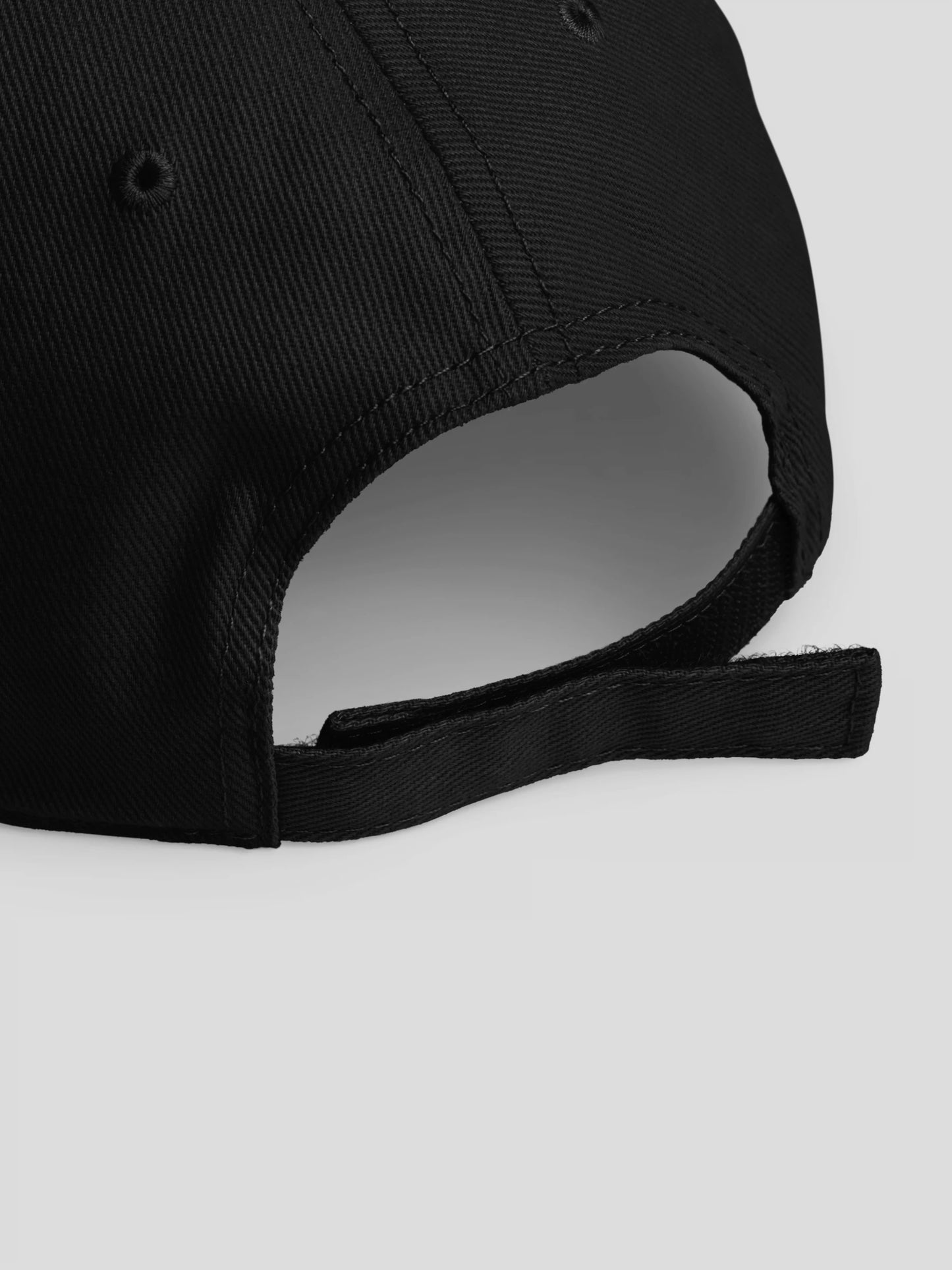 Close-up of REMNANT. COLD CAP black – fine stitching, matte texture, and tonal logo detailing.