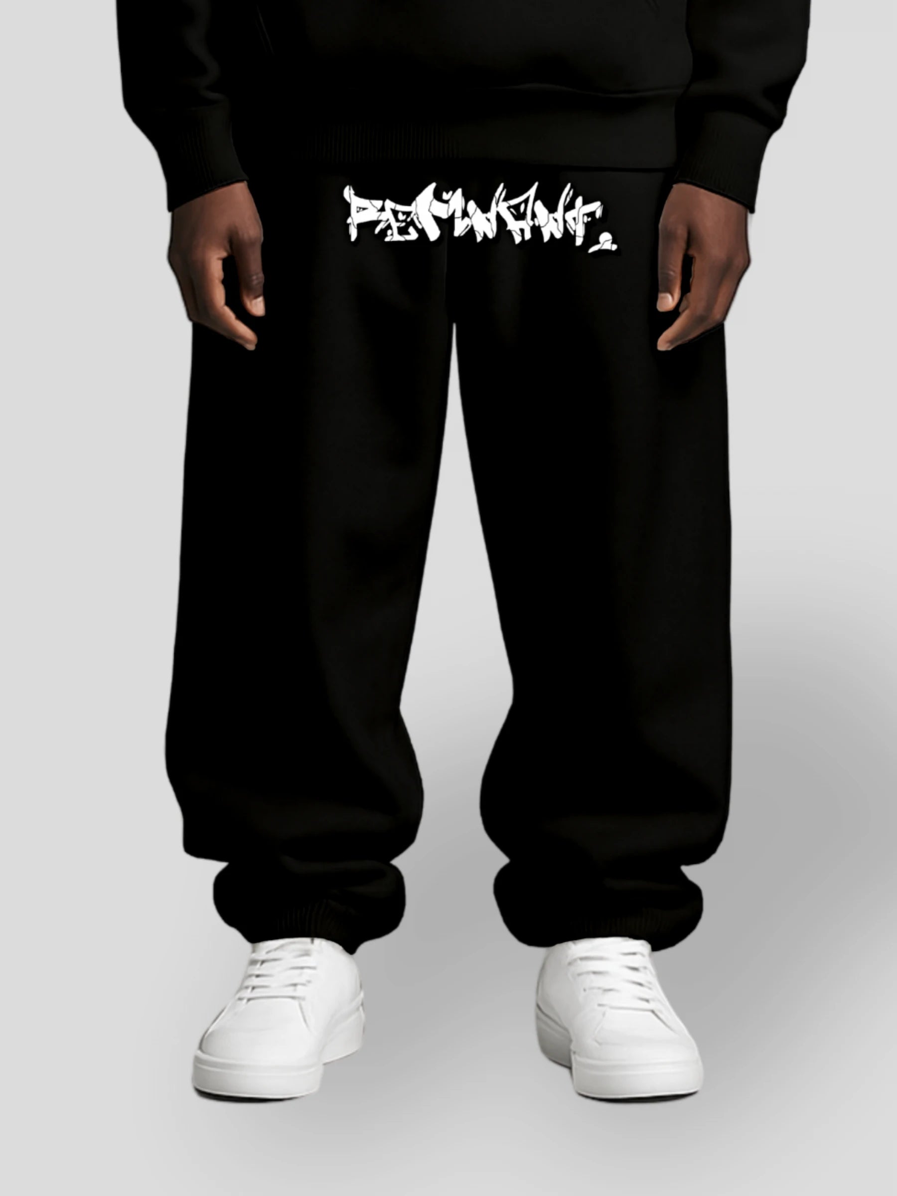 Model wearing the DROP.ØNE REMNANT. Baggy Sweatpants in black – oversized 380 GSM graffiti streetwear pants by MAXOMclo