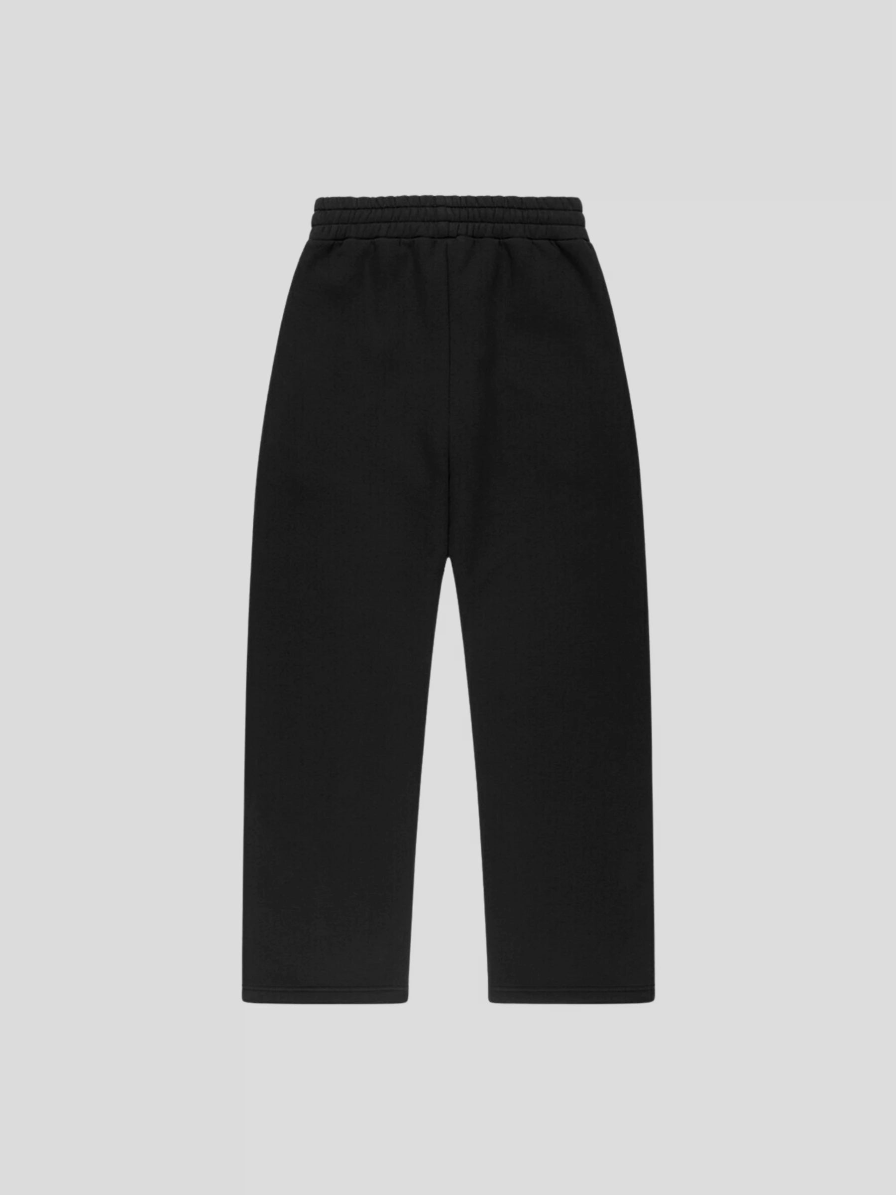 Back view of REMNANT. LIMITED oversized black sweatpants – minimalist streetwear silhouette