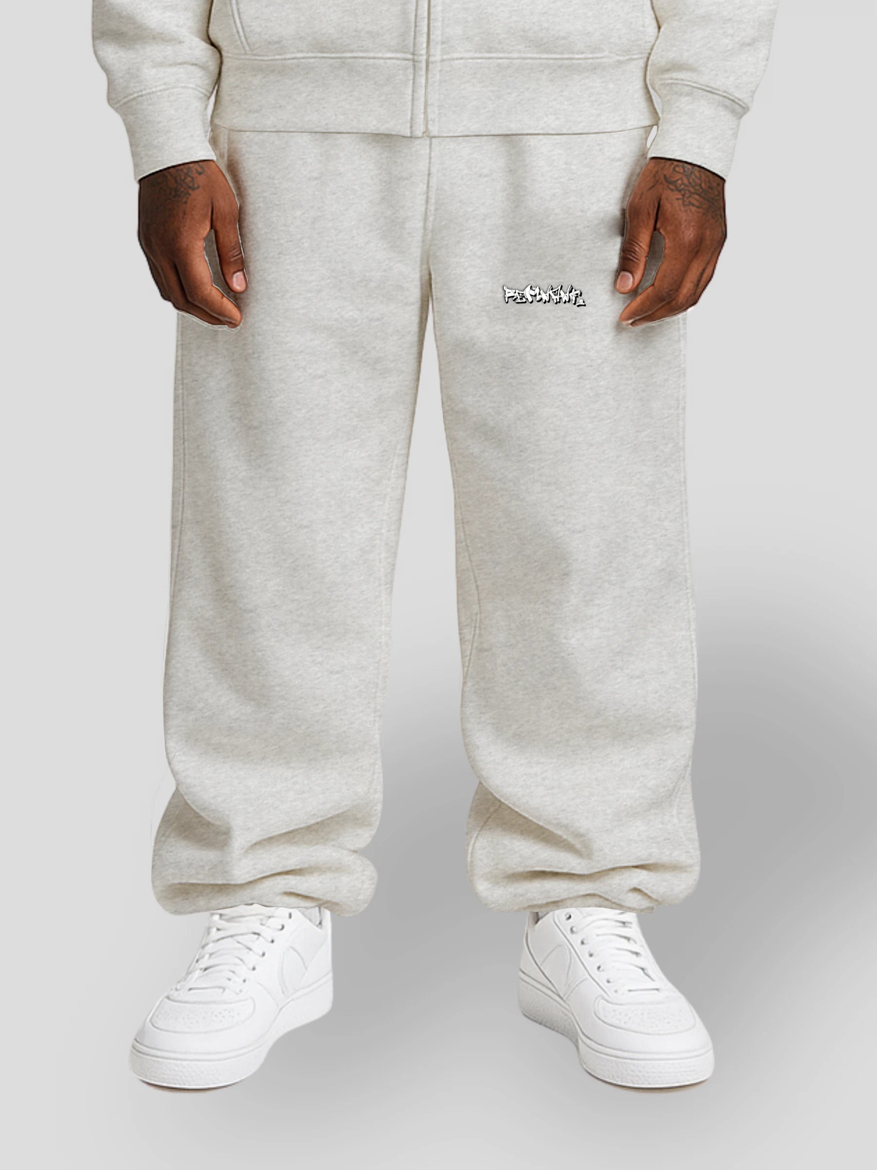 Model wearing REMNANT. LIMITED grey oversized streetwear sweatpants with graffiti print