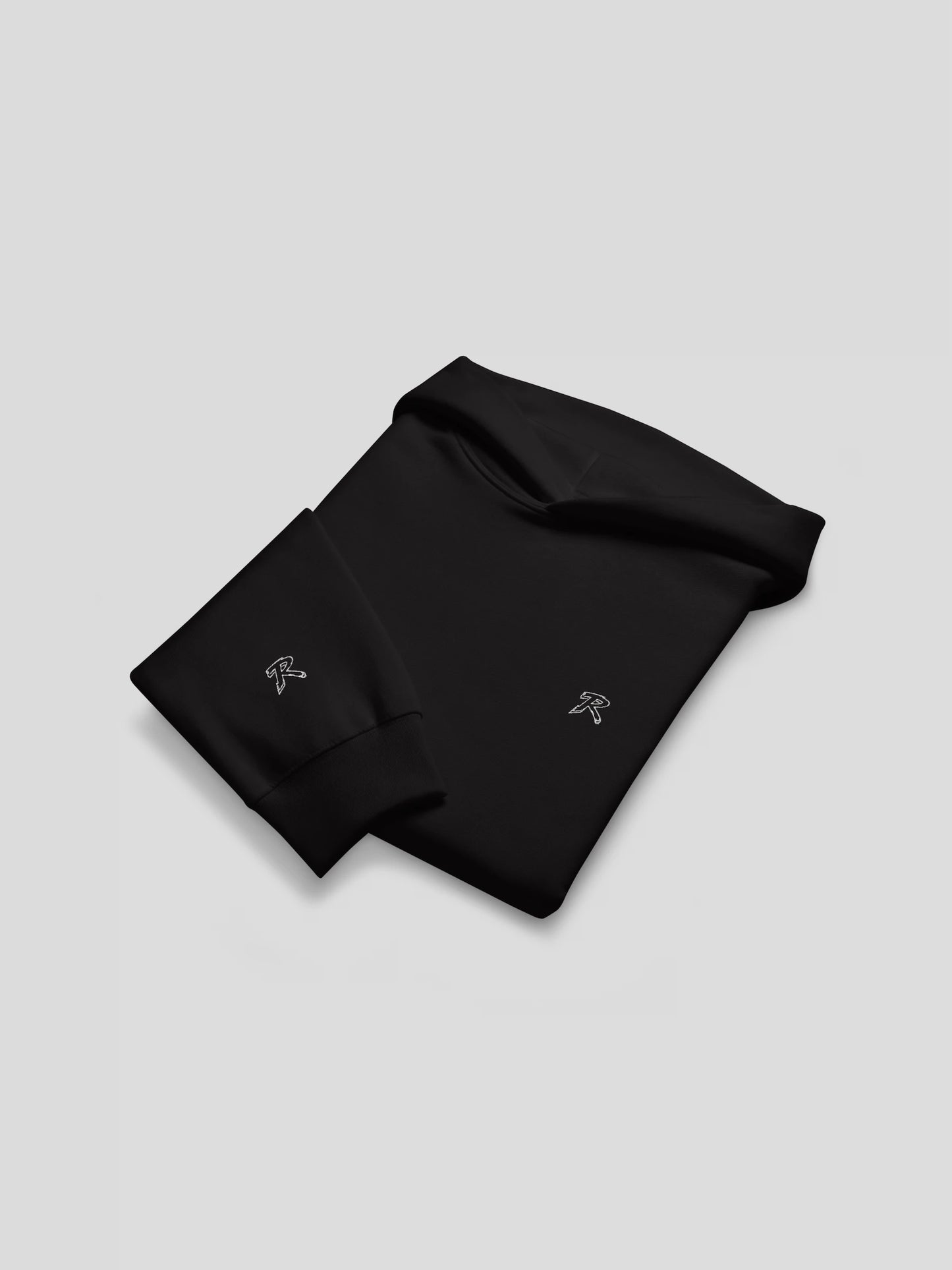 Folded flat lay of REMNANT. THEORY.01 Hoodie in NOIR Black – heavyweight cotton streetwear hoodie with subtle embroidered logo