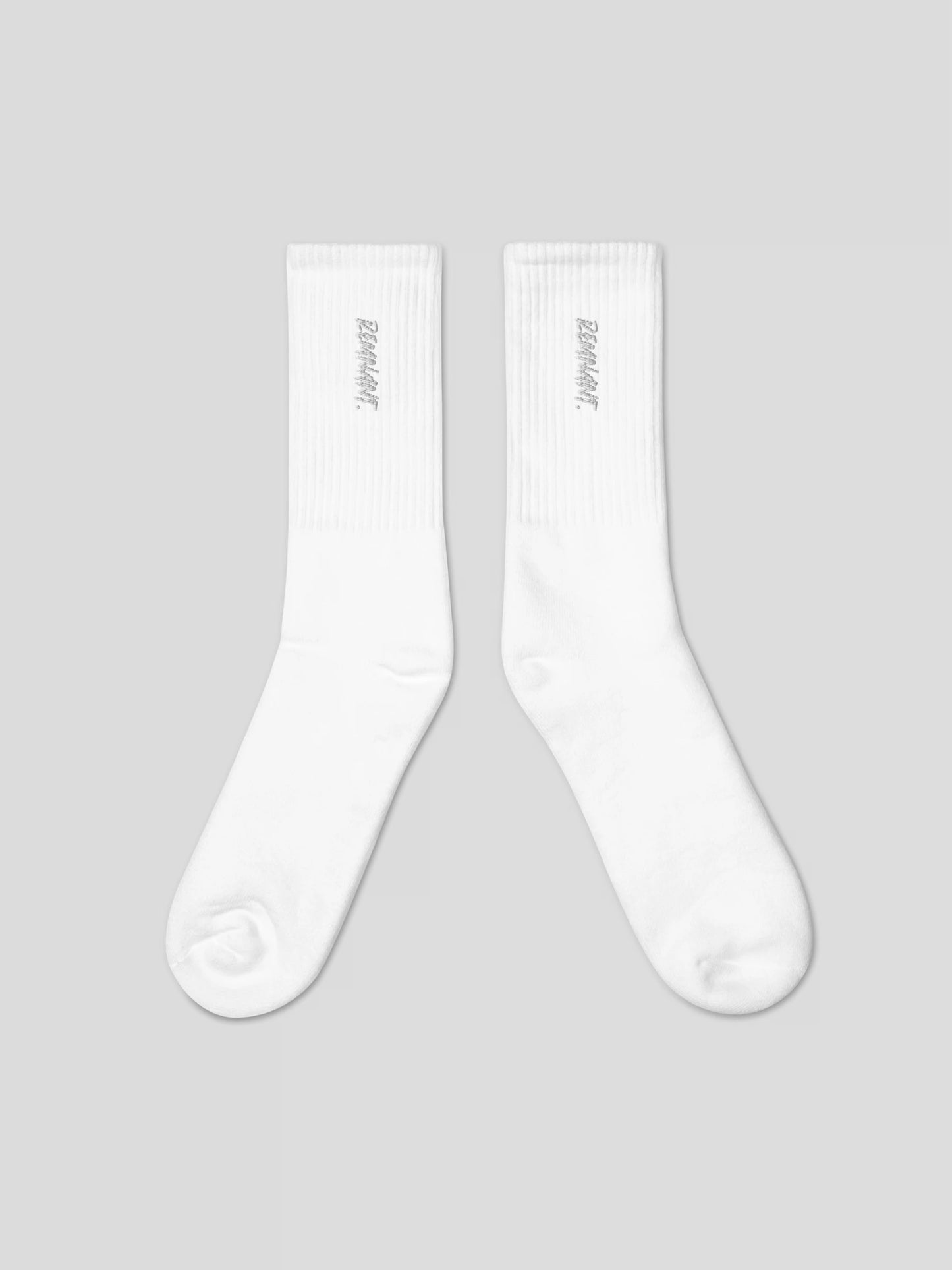 Close-up of REMNANT. embroidered logo on white streetwear socks