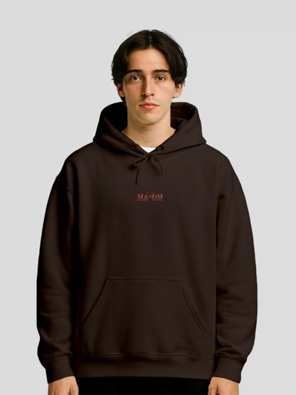Model wearing the Dark Chocolate Rose Graphic Hoodie by MAXOMclo – a brown floral streetwear hoodie with motivational slogan and luxury unisex fit.