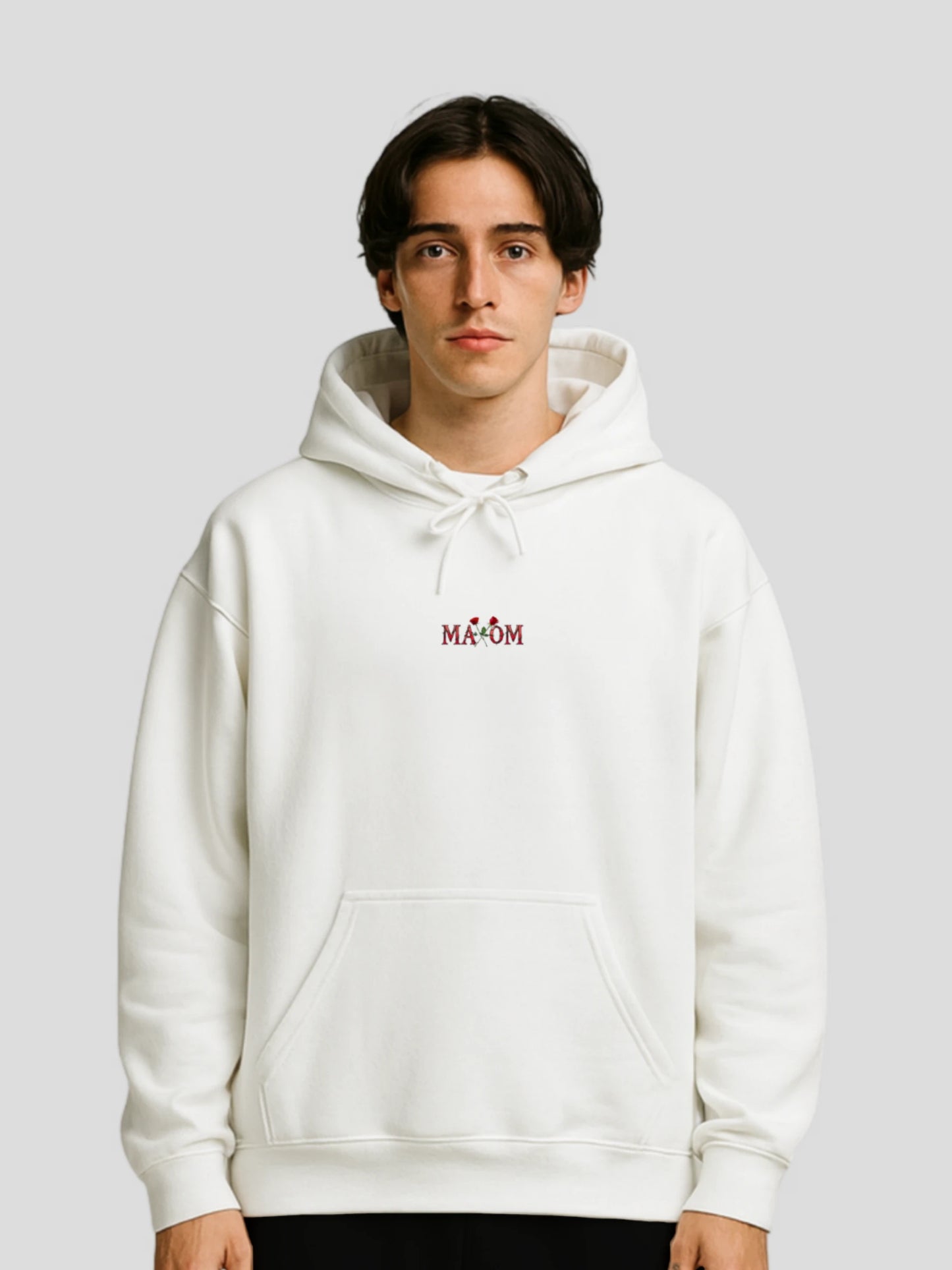 Male model wearing the White Rose Graphic Hoodie by MAXOMclo – a white unisex hoodie with rose print and motivational quote streetwear design for modern urban style.