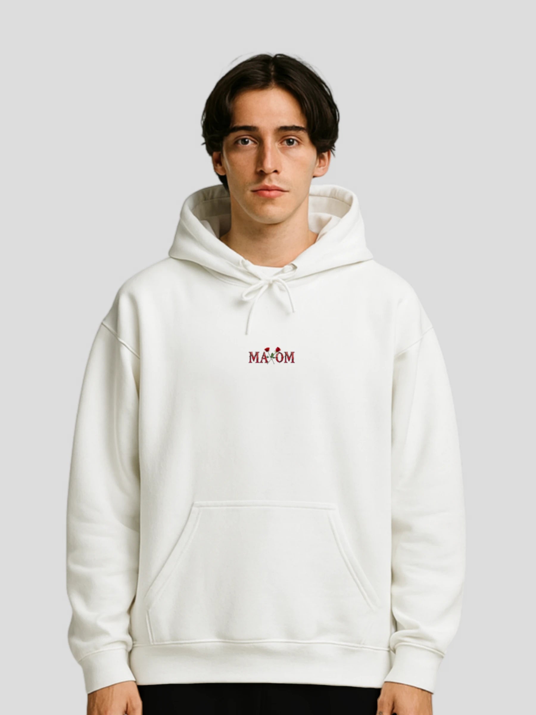 Male model wearing the White Rose Graphic Hoodie by MAXOMclo – a white unisex hoodie with rose print and motivational quote streetwear design for modern urban style.